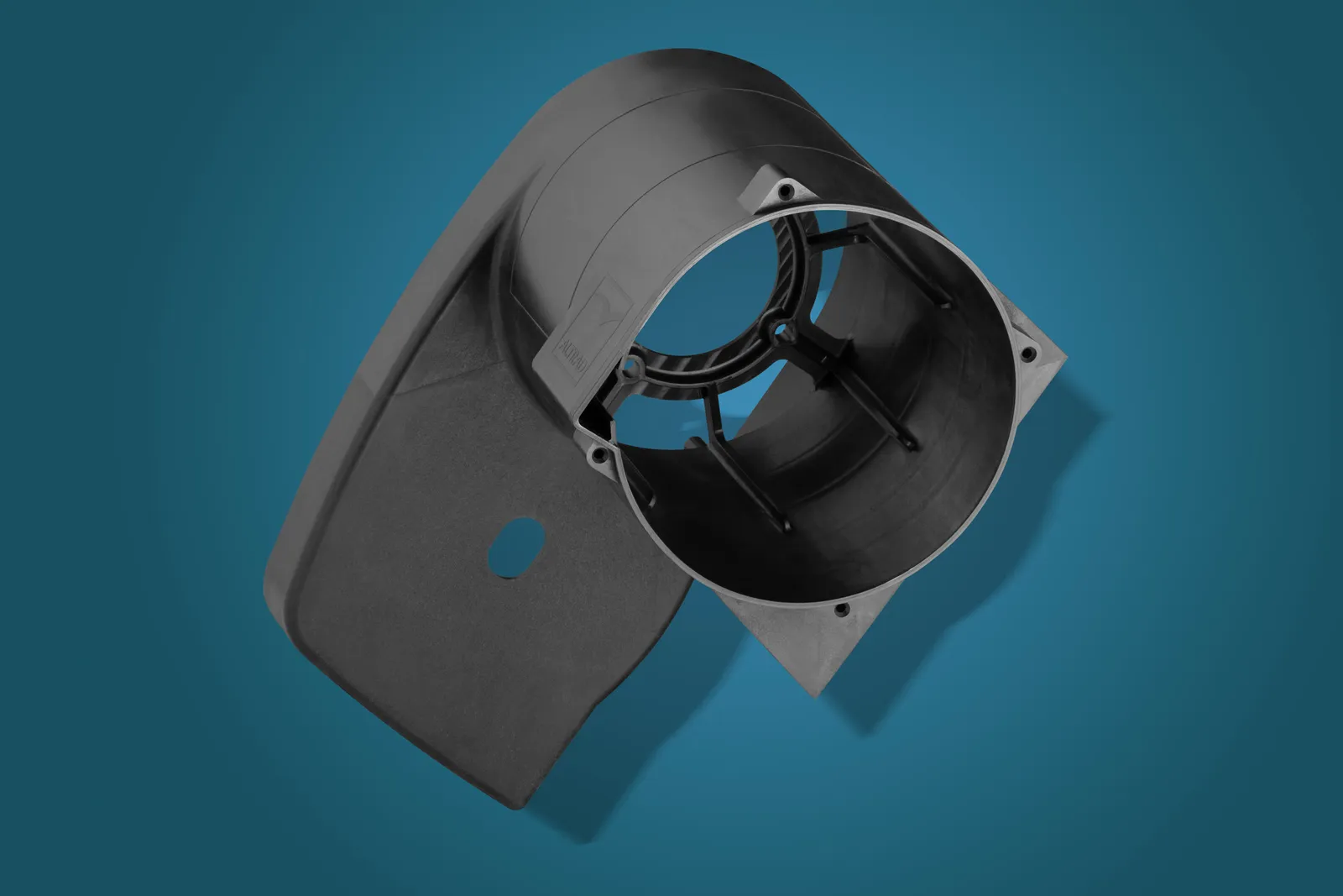 Black moulded plastic housing with a circular opening on a blue studio background