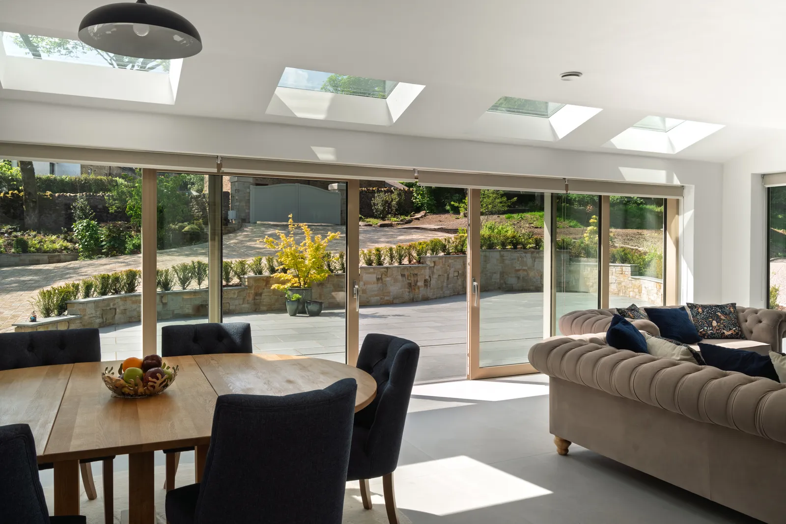 Open-plan living and dining room with full-width bifold doors opening onto the garden