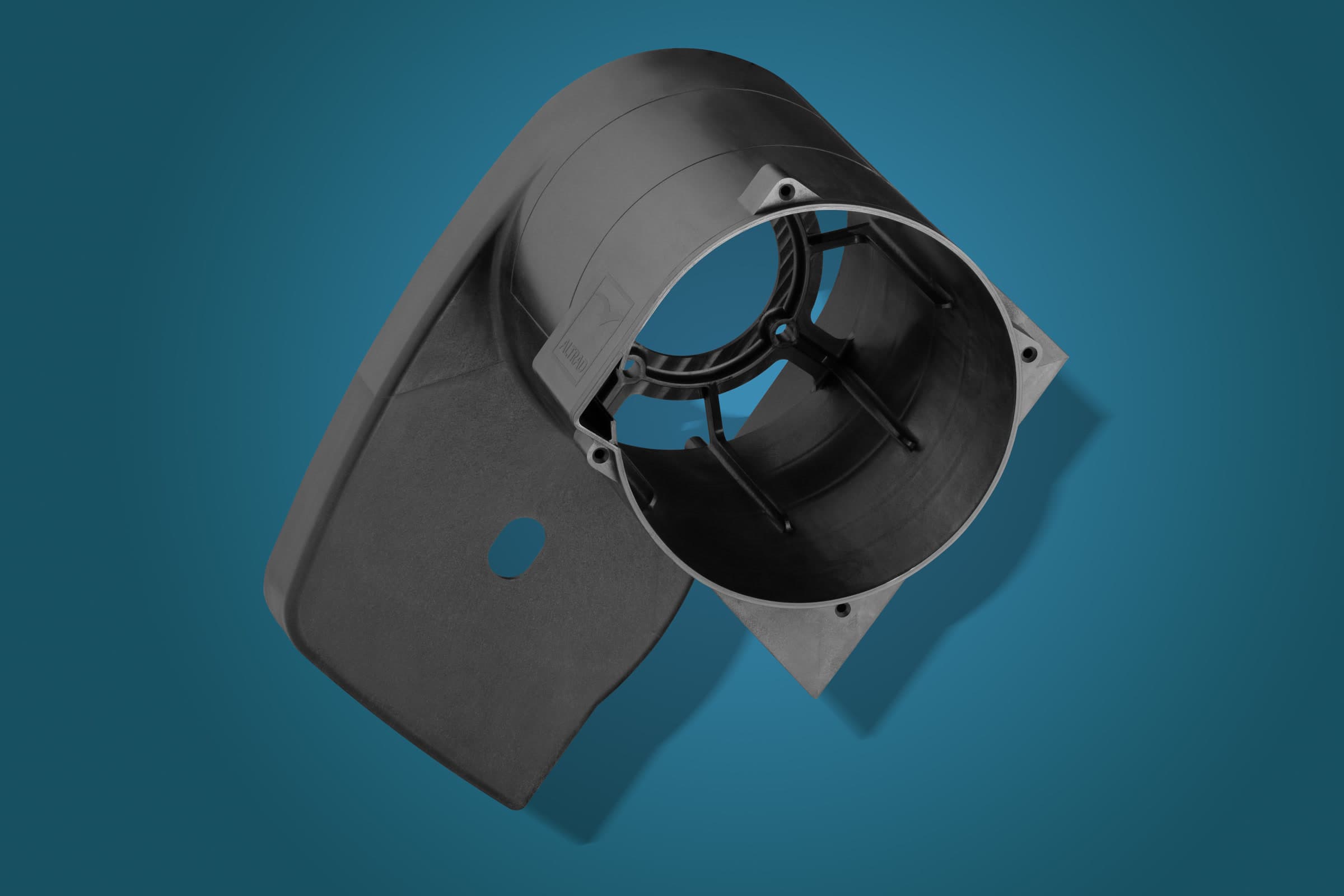 Black moulded plastic housing with a circular opening on a blue studio background