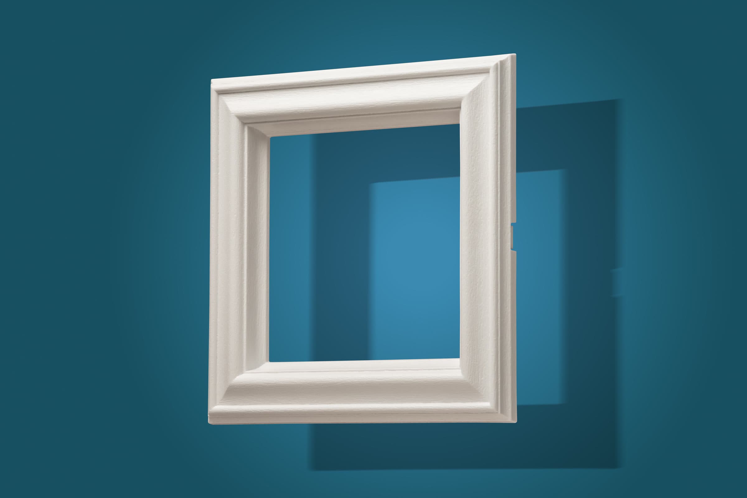 White moulded plastic frame photographed on a blue studio background