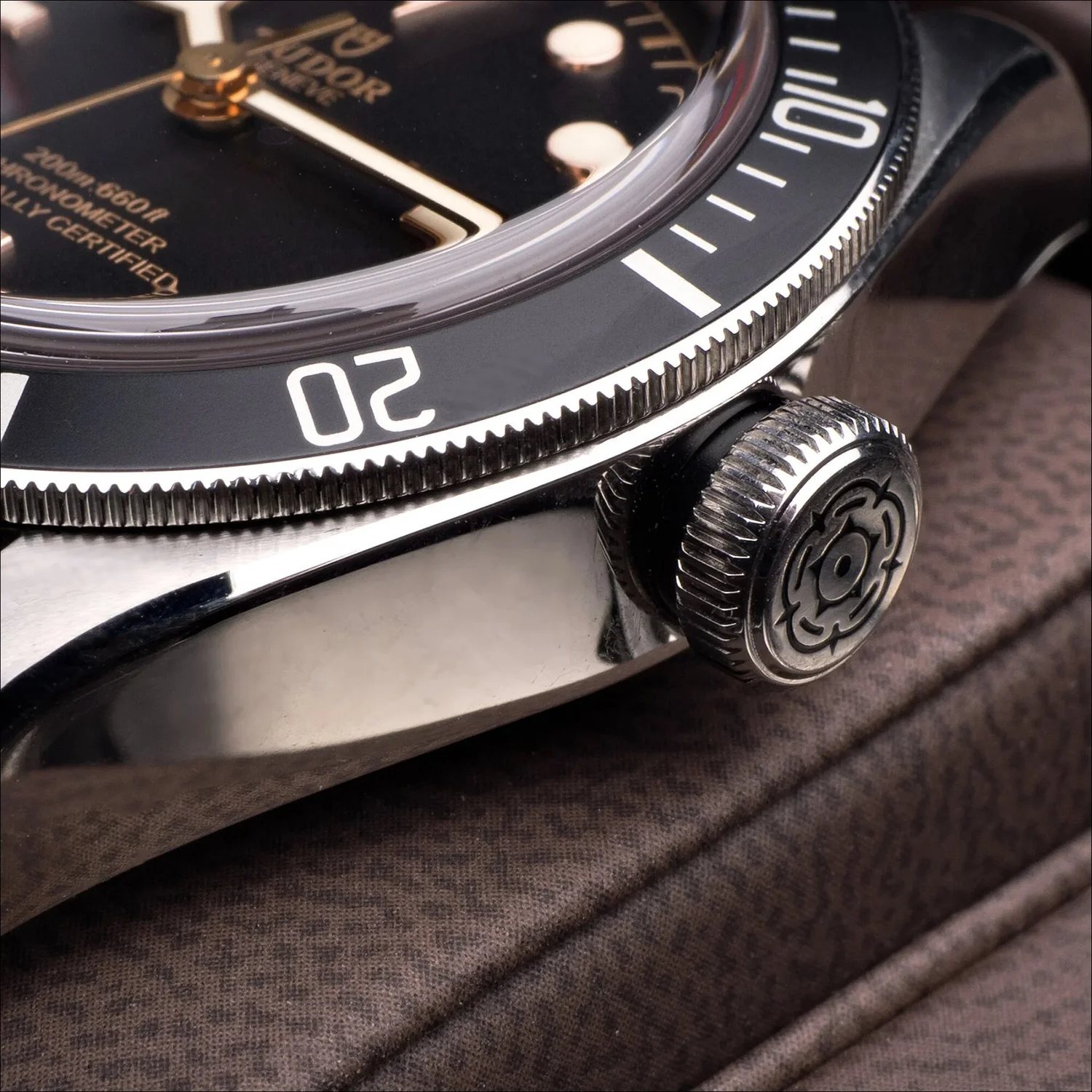 Tudor watch crown with rose engraving, studio product photography