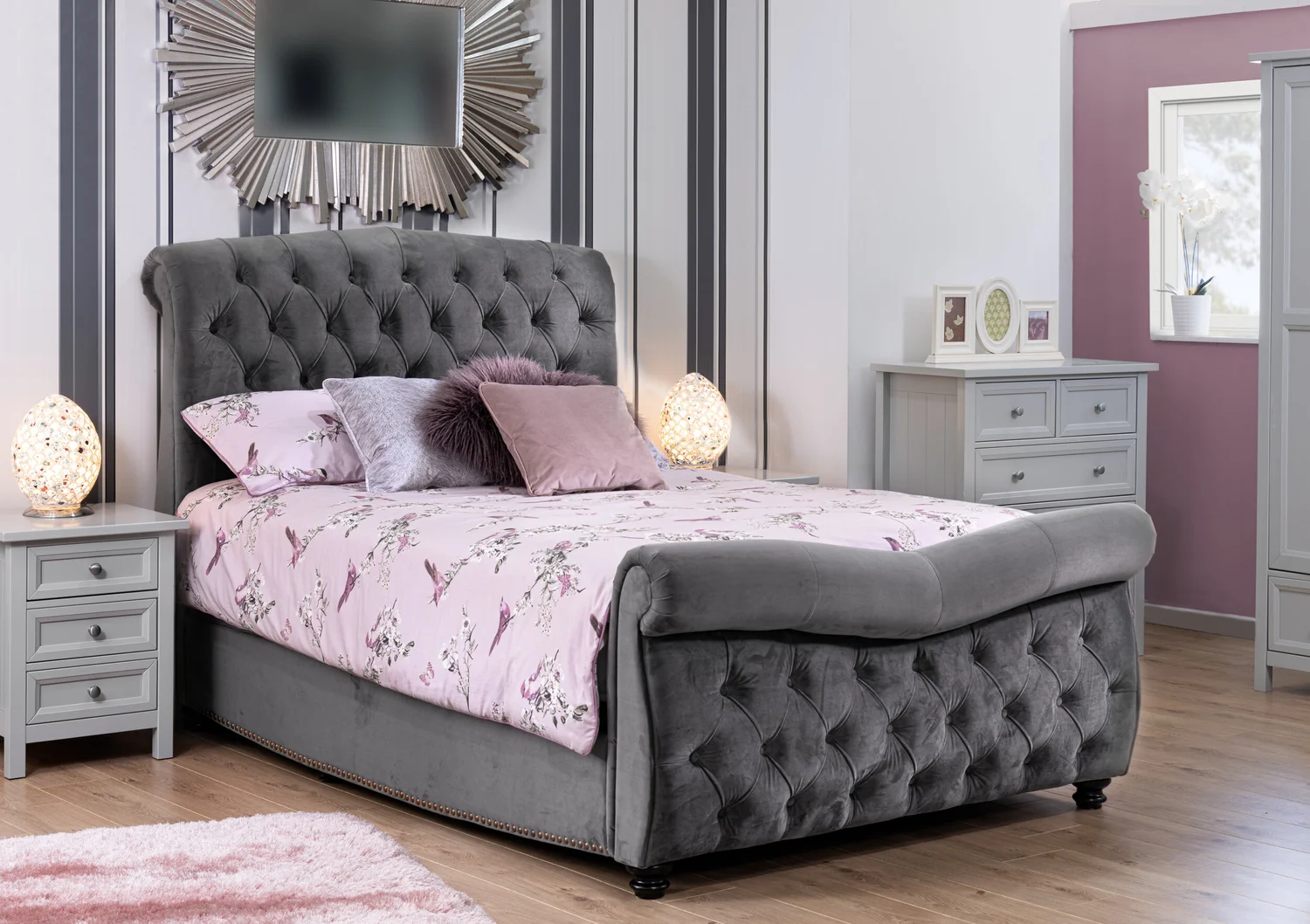 Grey velvet buttoned sleigh bed styled in a pink and grey bedroom set