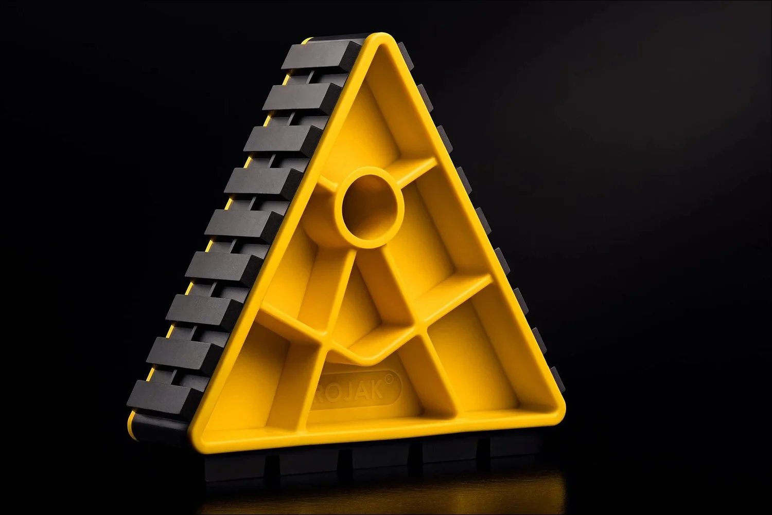 Yellow and black plastic wheel chock, product photography