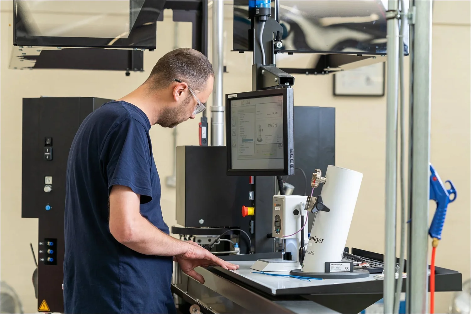 Operator using a Schleuniger pull tester in a Lancashire manufacturing facility