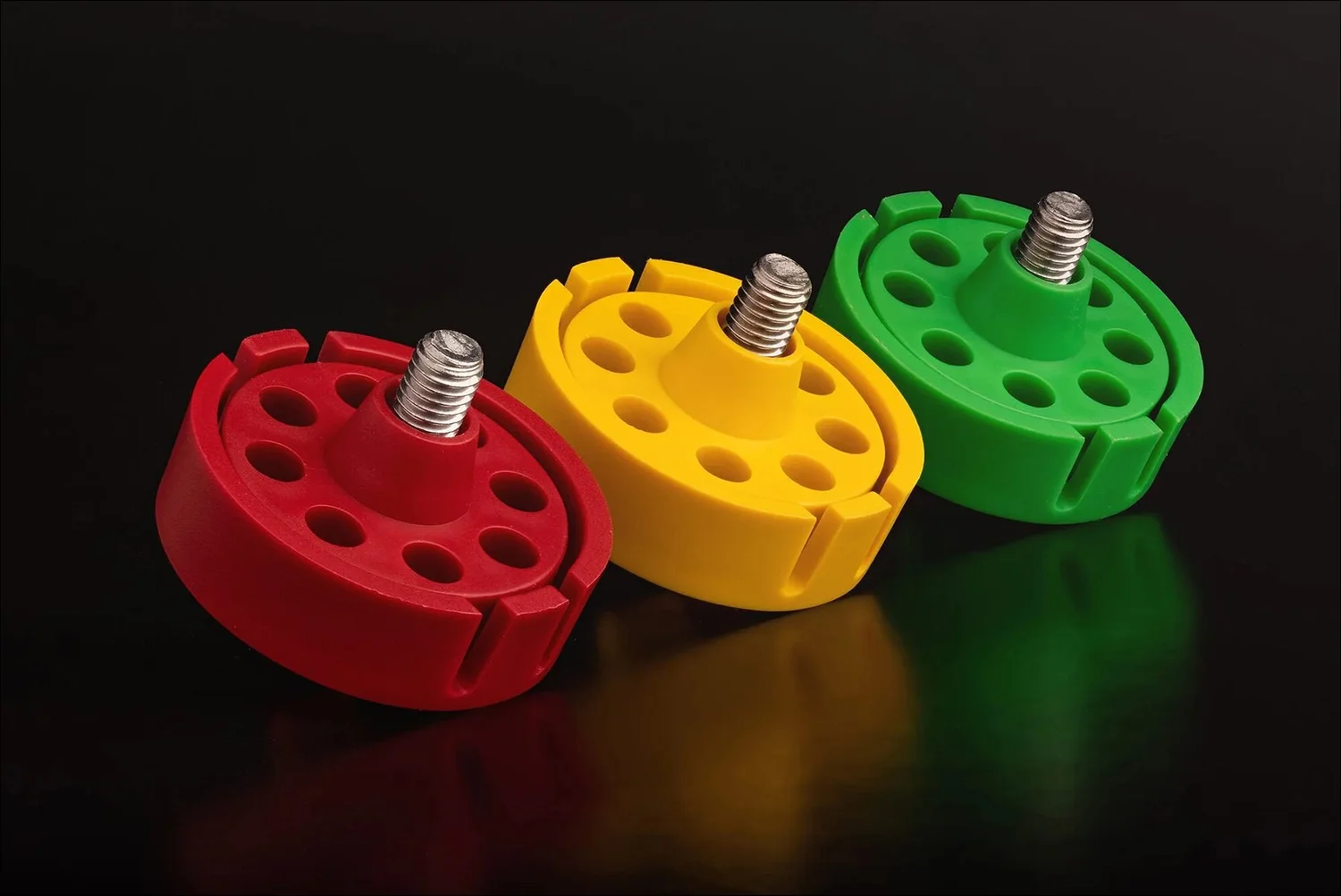 Red yellow green plastic molded components with central bolts product photography