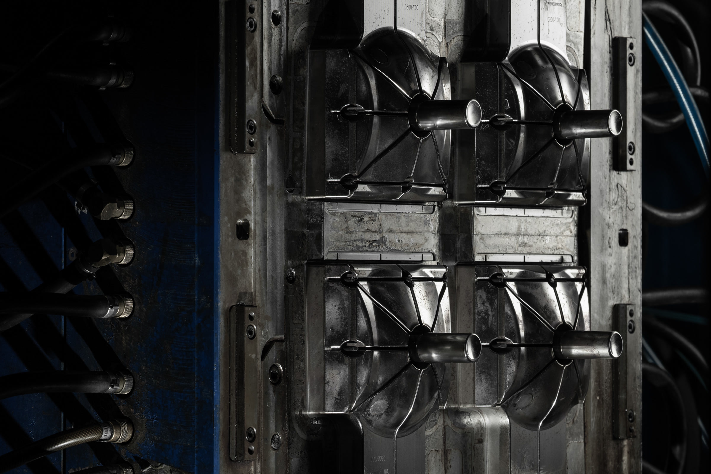 Dark close-up inside an open industrial moulding machine