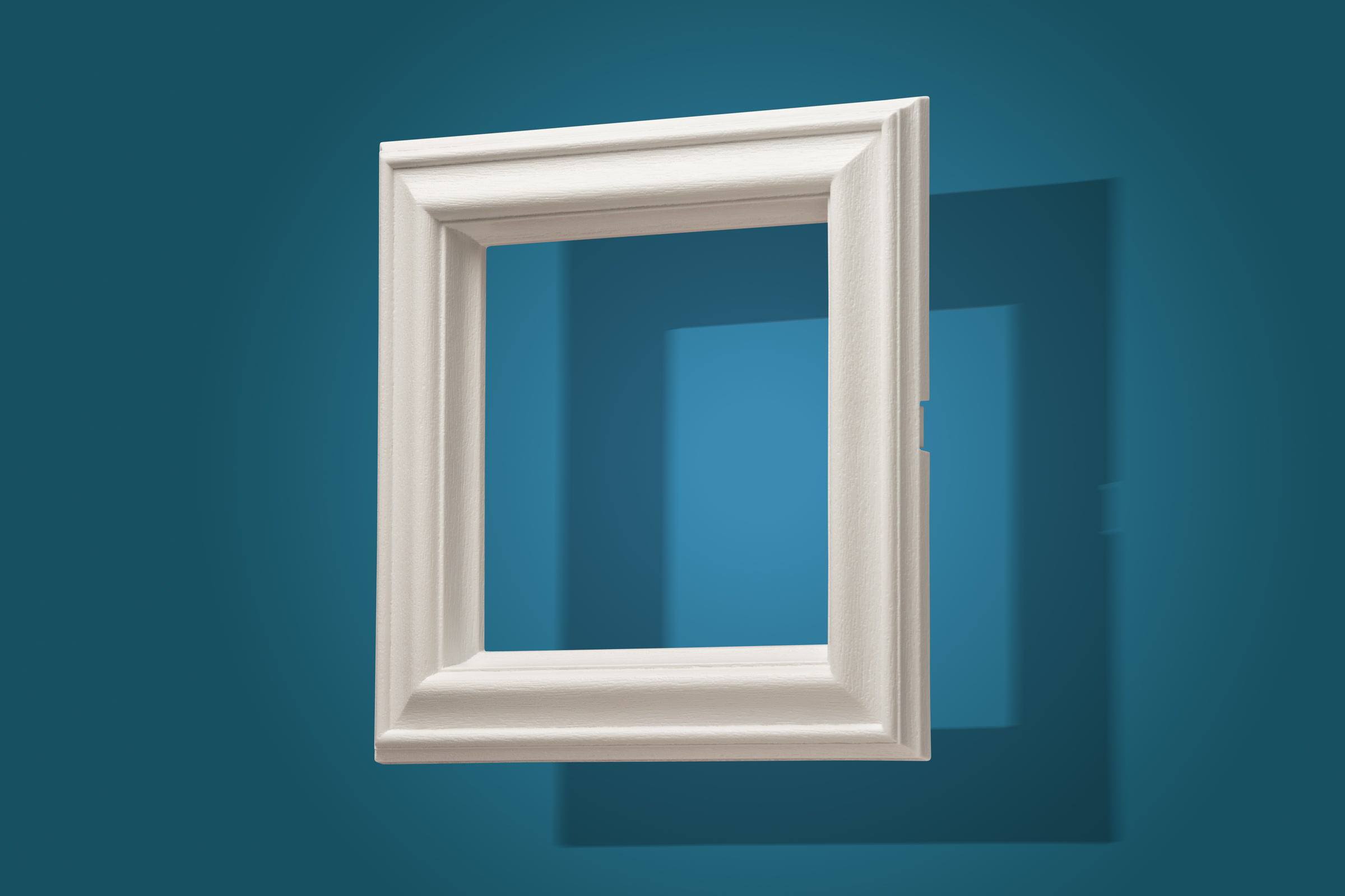 White moulded plastic frame photographed on a blue studio background