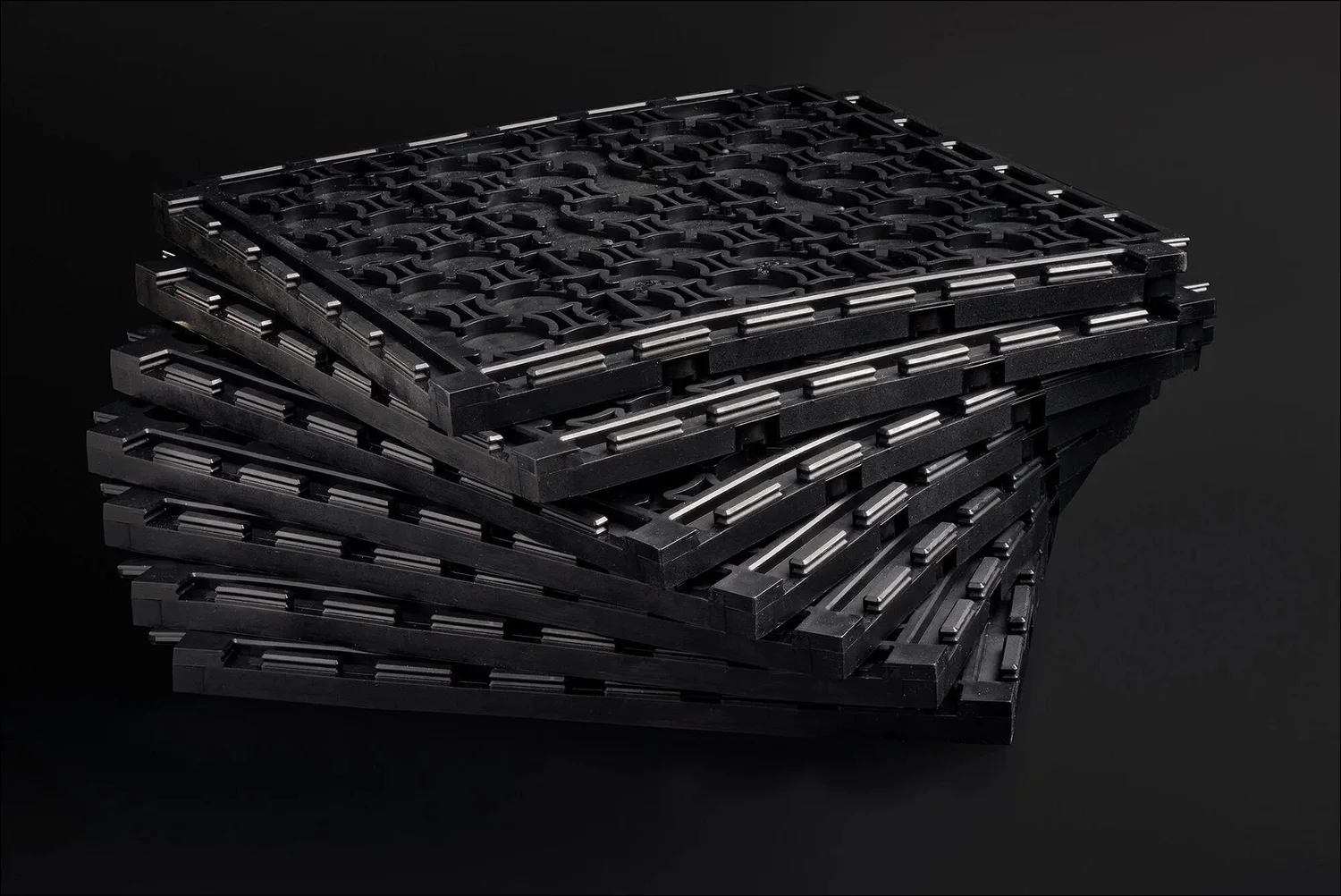 Modular black plastic flooring tiles stacked