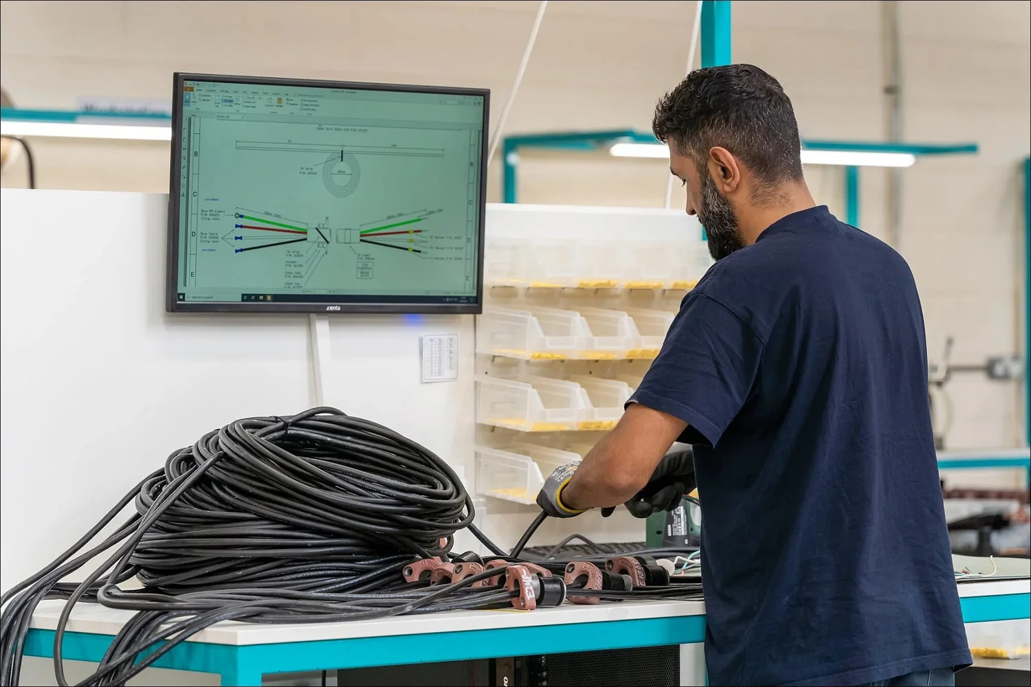 Manufacturing worker assembling a cable harness from a digital diagram