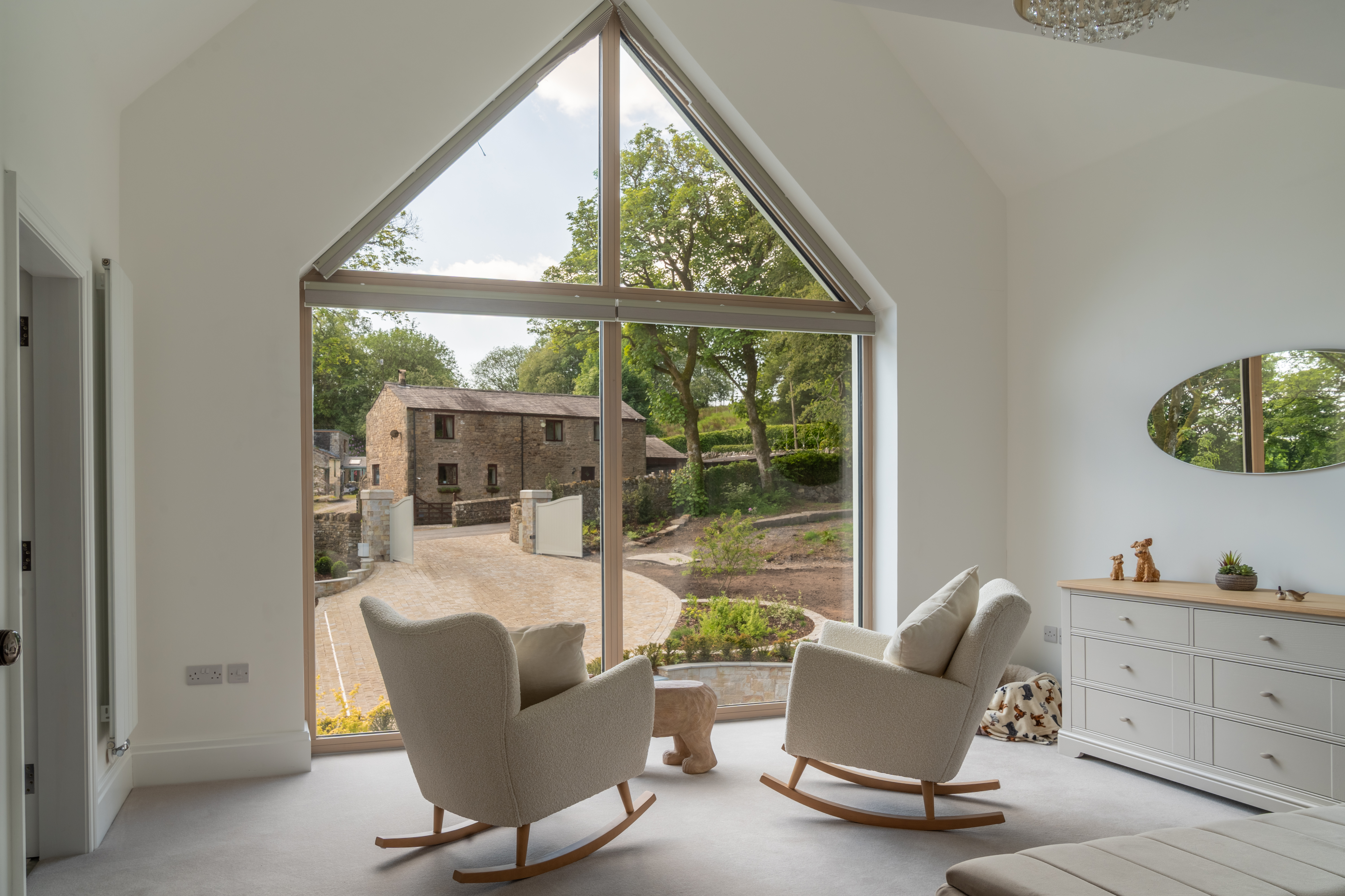 Vaulted sitting room with full-height gable glazing overlooking the countryside