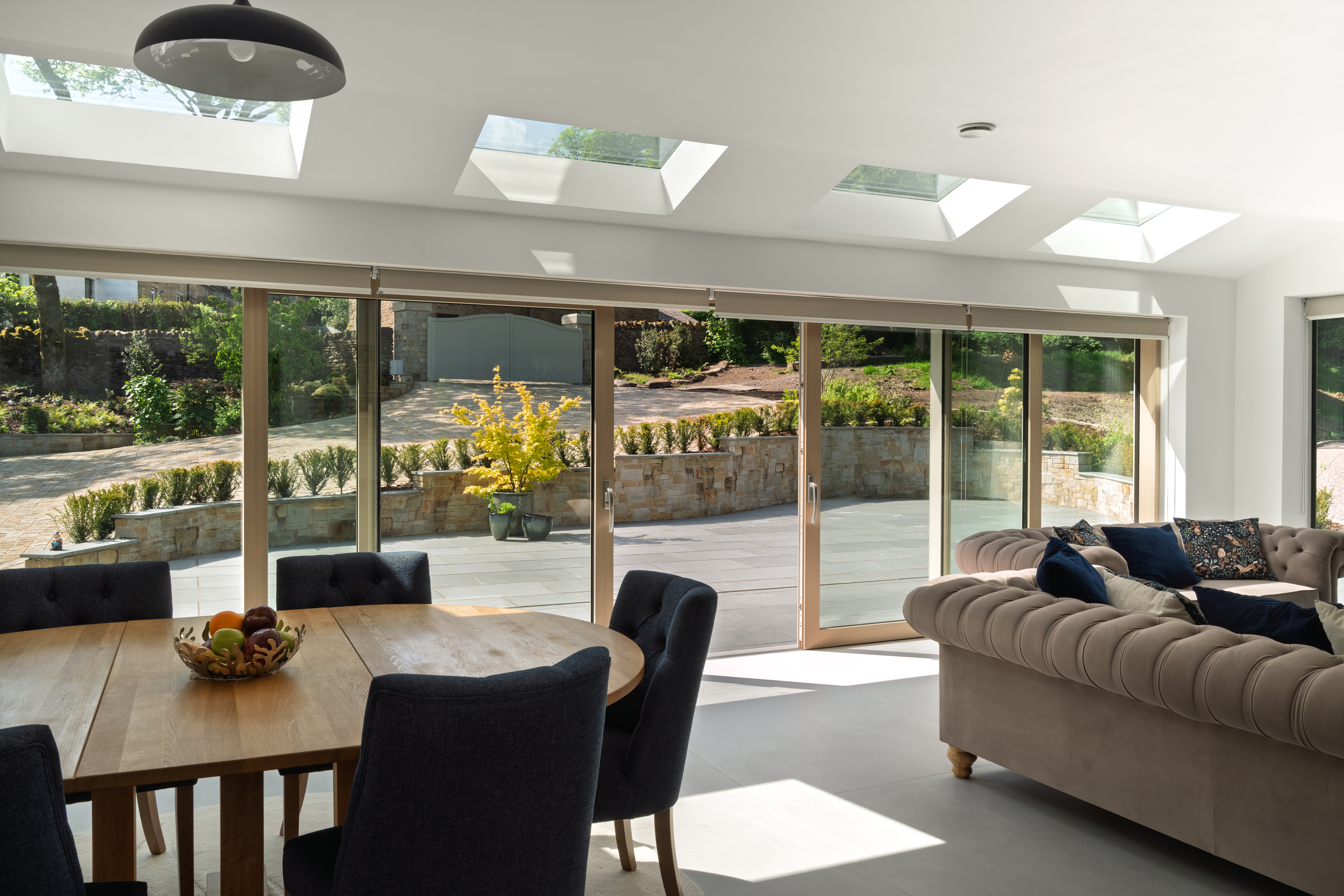 Open-plan living and dining room with full-width bifold doors opening onto the garden